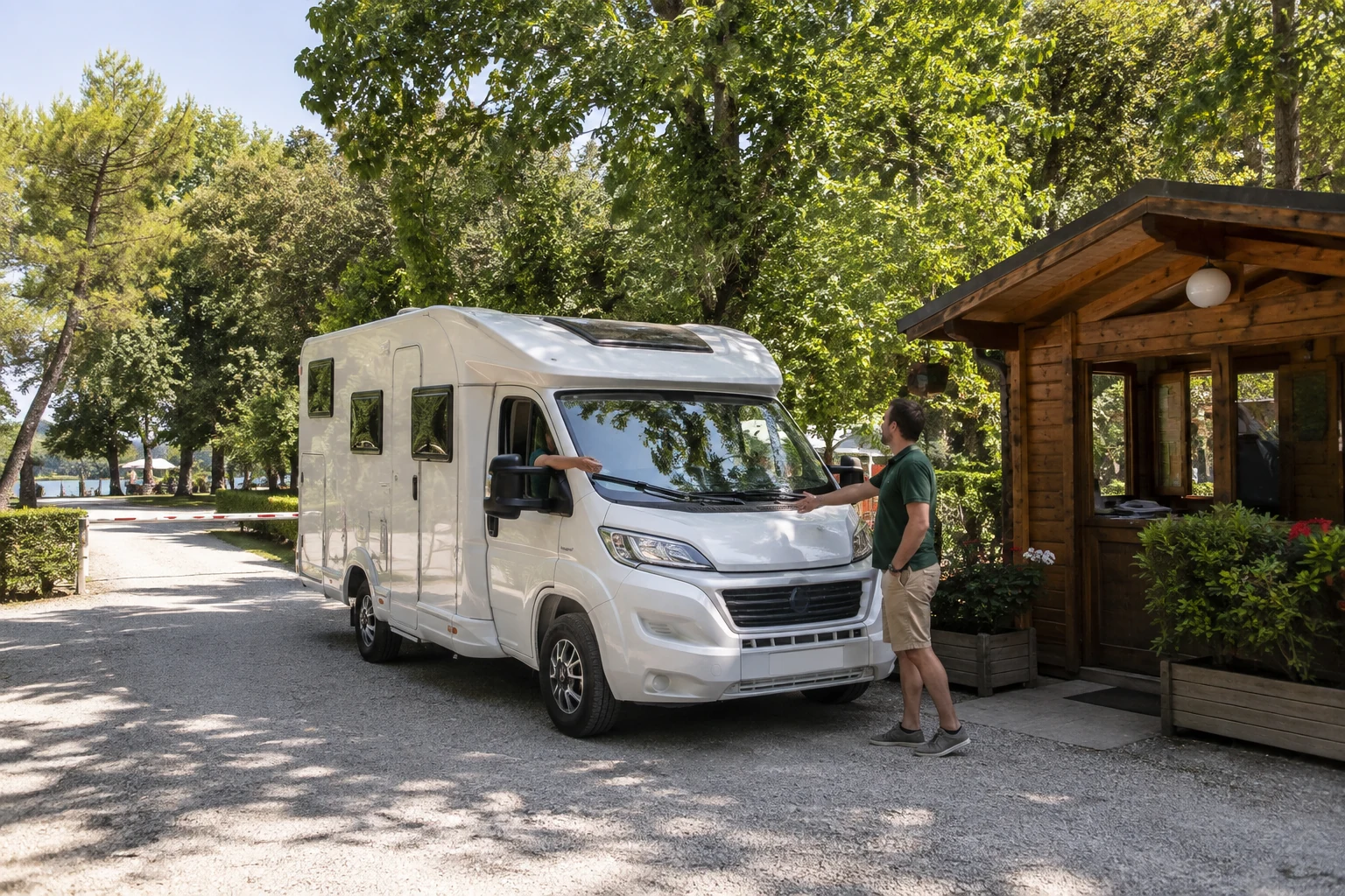 Un camper arriva alla reception di un campeggio immerso nel verde.