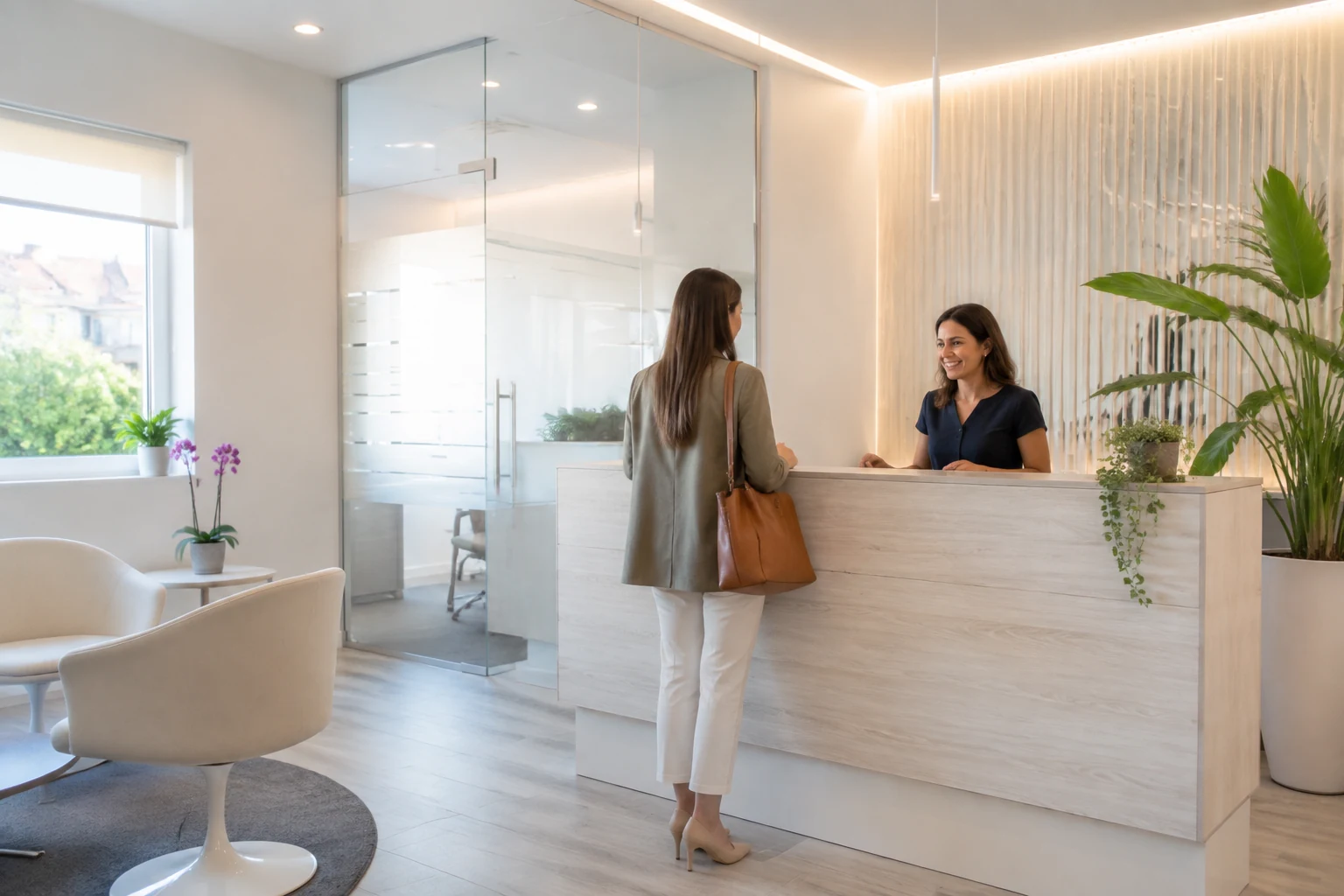 Una segretaria accoglie una persona nella reception luminosa di uno studio odontoiatrico.