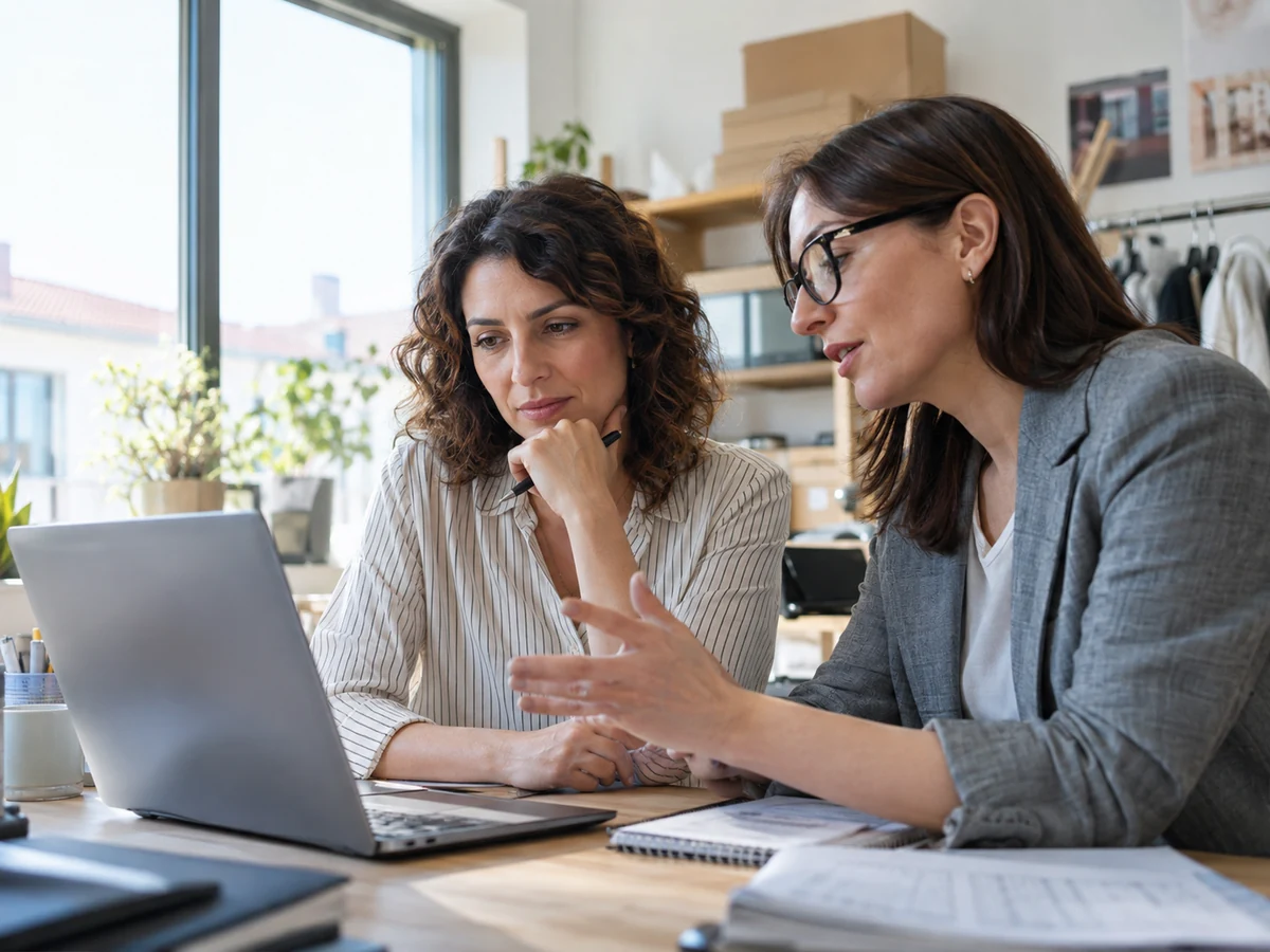 Due professioniste esaminano insieme un computer portatile in ufficio
